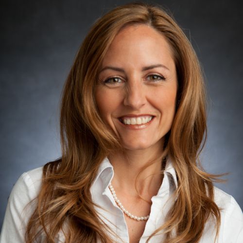 A woman with long hair and smiling at the camera.