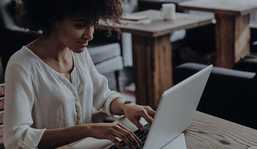 A woman is typing on her laptop